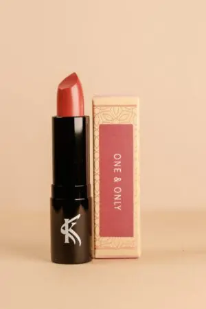 A lipstick that is sitting next to a box.